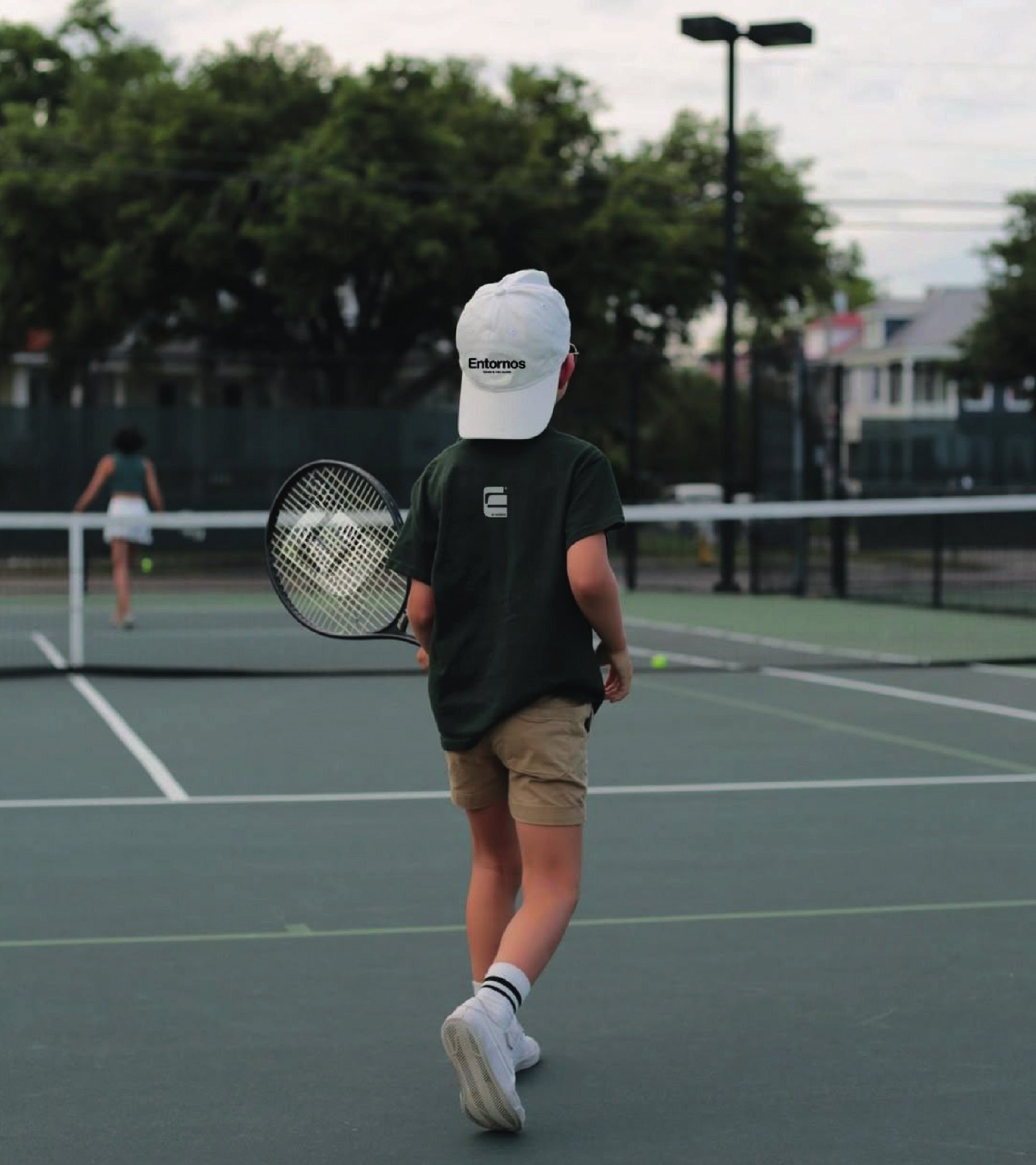 Niño con playera y gorra Entornos en cancha de tenis
