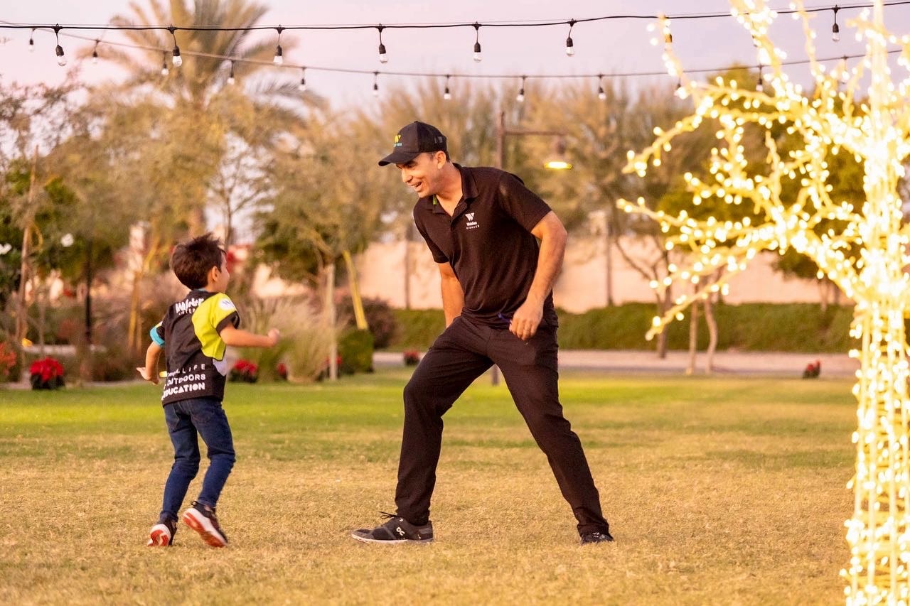 Coach de Entornos jugando con niño bajo luces de navidad