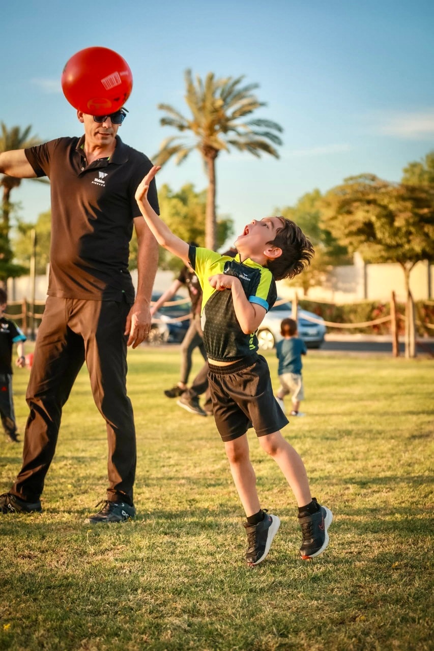 Coach de Entornos con niño saltando por pelota roja