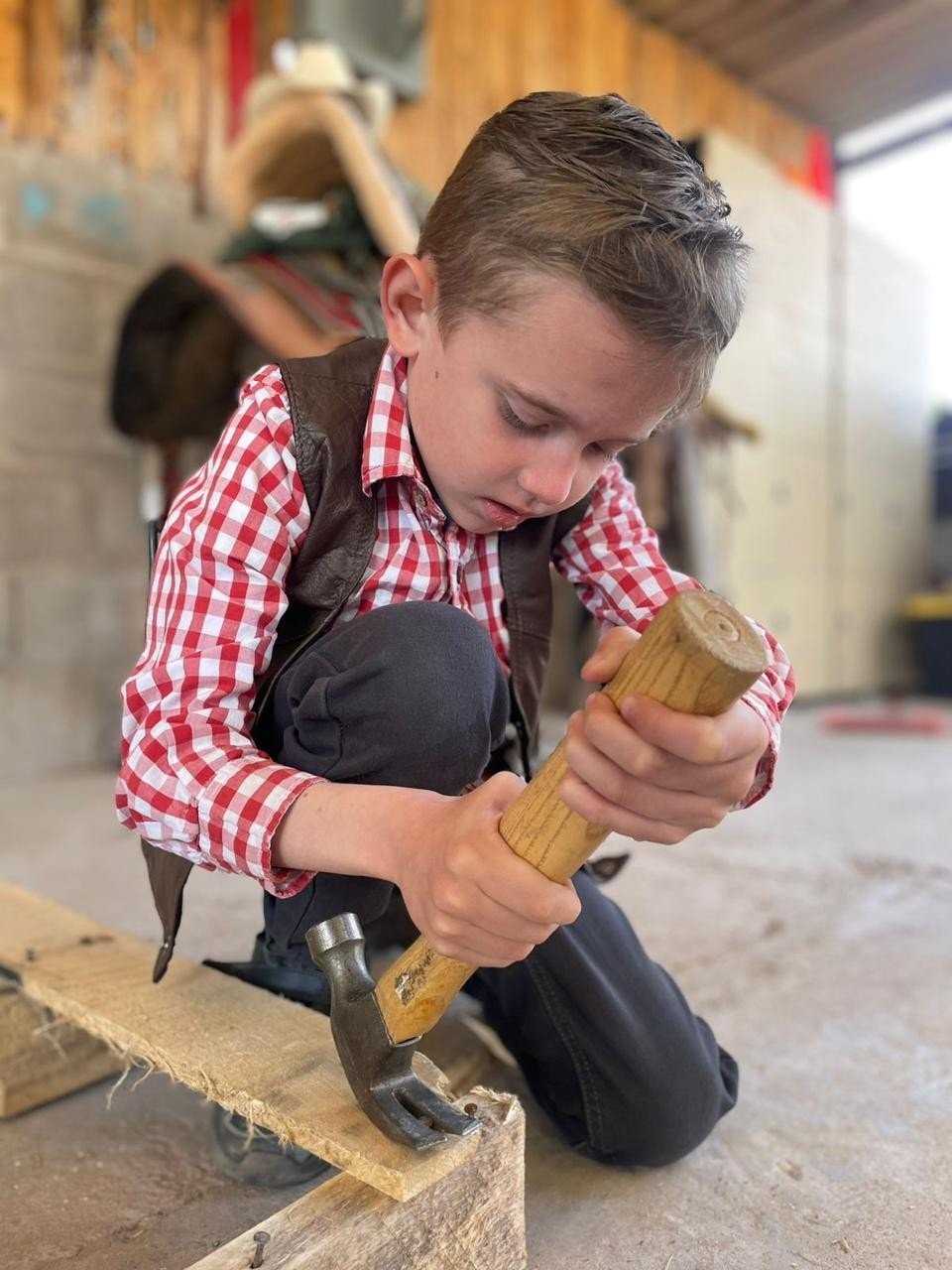 Niño aprendiendo carpintería con martillo